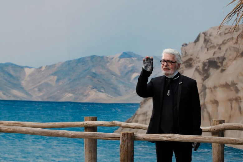 FILE - In this Tuesday, Oct.2, 2018 file photo, Karl Lagerfeld waves after the presentation of Chanel Spring/Summer 2019 ready-to-wear fashion collection in Paris. Chanel¿s iconic couturier, Karl Lagerfeld, whose accomplished designs as well as trademark white ponytail, high starched collars and dark enigmatic glasses dominated high fashion for the last 50 years, has died. He was around 85 years old. (AP Photo/Christophe Ena, File ) Paris Fashion 2018 Chanel