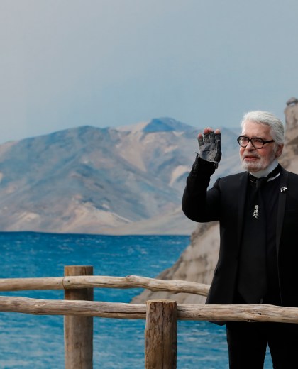 FILE - In this Tuesday, Oct.2, 2018 file photo, Karl Lagerfeld waves after the presentation of Chanel Spring/Summer 2019 ready-to-wear fashion collection in Paris. Chanel¿s iconic couturier, Karl Lagerfeld, whose accomplished designs as well as trademark white ponytail, high starched collars and dark enigmatic glasses dominated high fashion for the last 50 years, has died. He was around 85 years old. (AP Photo/Christophe Ena, File ) Paris Fashion 2018 Chanel