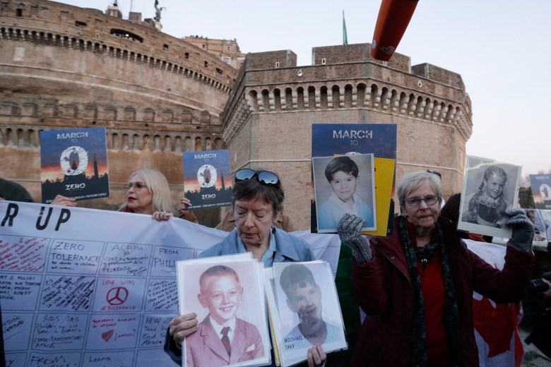 People hold up pictures of what they claim to be victims of priests sexual abuse as they gather during a twilight vigil prayer near Castle Sant' Angelo, in Rome, Thursday, Feb. 21, 2019. Pope Francis opened a landmark sex abuse prevention summit Thursday by warning senior Catholic figures that the faithful are demanding concrete action against predator priests and not just words of condemnation. (AP Photo/Gregorio Borgia) Vatican Sex Abuse