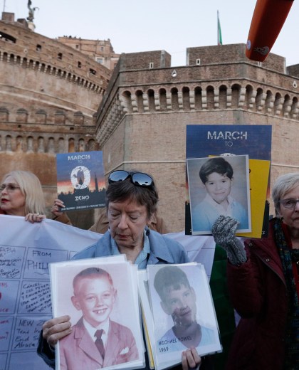 People hold up pictures of what they claim to be victims of priests sexual abuse as they gather during a twilight vigil prayer near Castle Sant' Angelo, in Rome, Thursday, Feb. 21, 2019. Pope Francis opened a landmark sex abuse prevention summit Thursday by warning senior Catholic figures that the faithful are demanding concrete action against predator priests and not just words of condemnation. (AP Photo/Gregorio Borgia) Vatican Sex Abuse