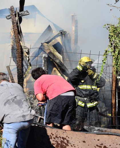 Bomberos voluntarios y vecinos apagan el fuego de un depósito en la calle Mariano Moreno 2448. (Foto: Andrés Maripe)