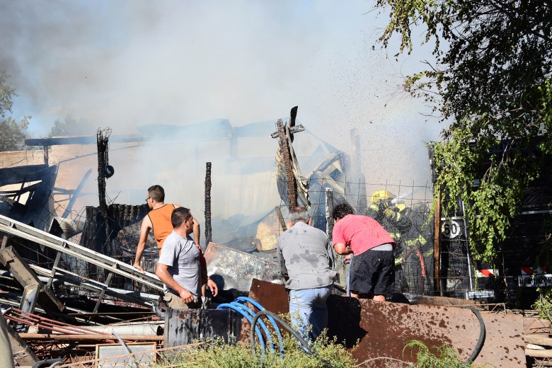 Bomberos voluntarios y vecinos apagan el fuego de un depósito en la calle Mariano Moreno 2448. (Foto: Andrés Maripe)