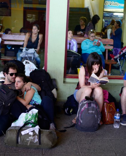 En la terminal de Bariloche, jóvenes leen antes de emprender viaje. (Foto: Alfredo Leiva)