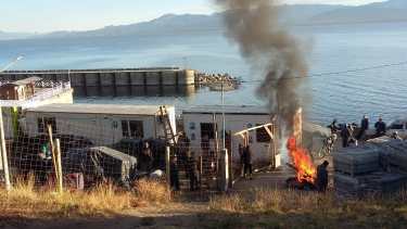 Los obreros realizan la quema de pallets y gomas en el obrador. 
