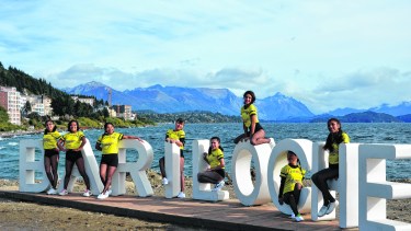 Jóvenes del grupo de danza Commac de Humahuaca, Jujuy, posan para llevarse una foto grupal en el cartel de Bariloche. Foto: Chino Leiva