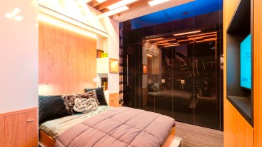 La cama desplegada y un ambiente suntuoso para la noche. Las puertas corredizas del fondo ocultan la mini cocina.