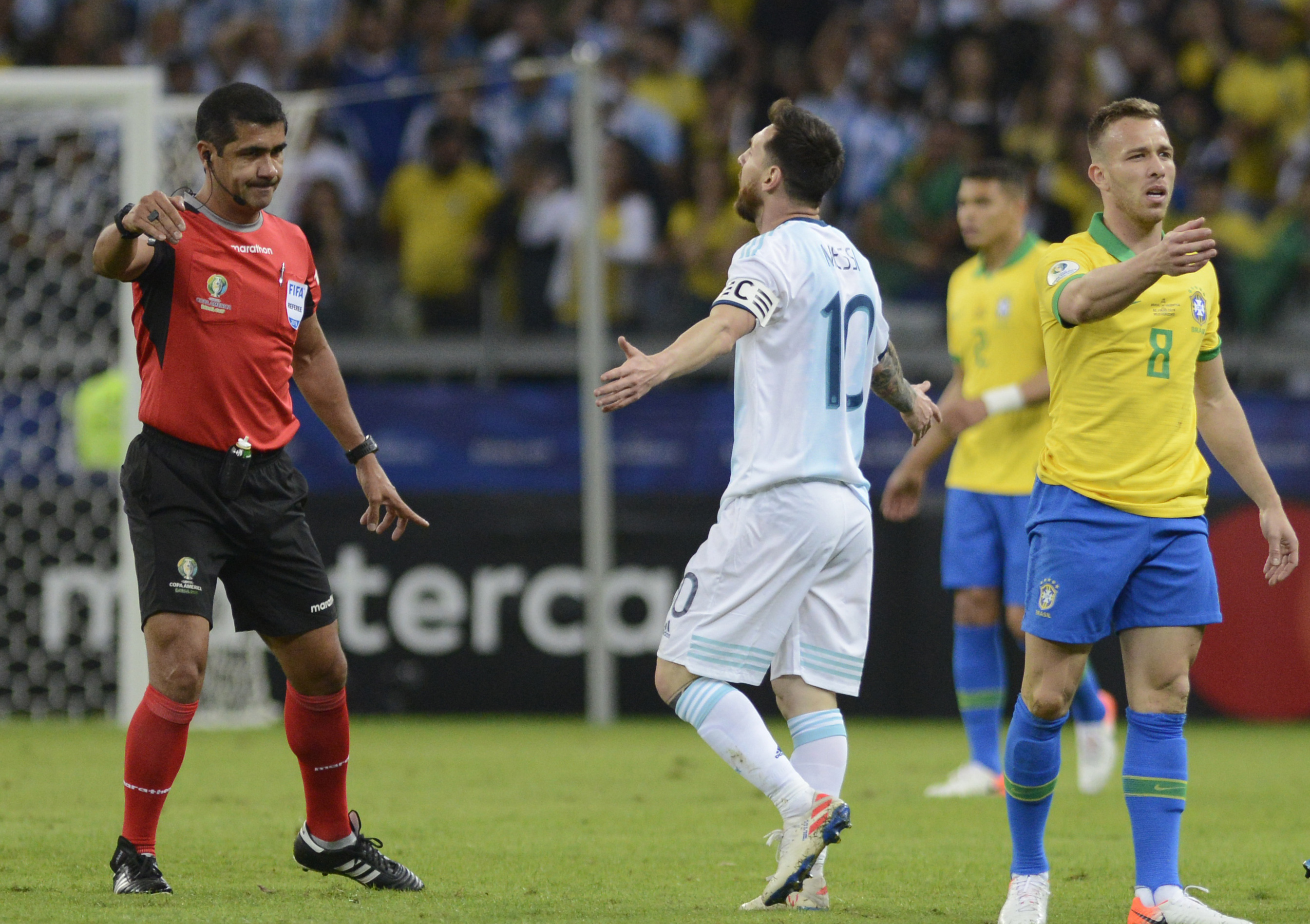 Lionel Messi se queja con el árbitro ecuatoriano Roddy Zambrano durante la semifinal ante Brasil en la Copa América en Belo Horizonte (AP Foto/Eugenio Savio)