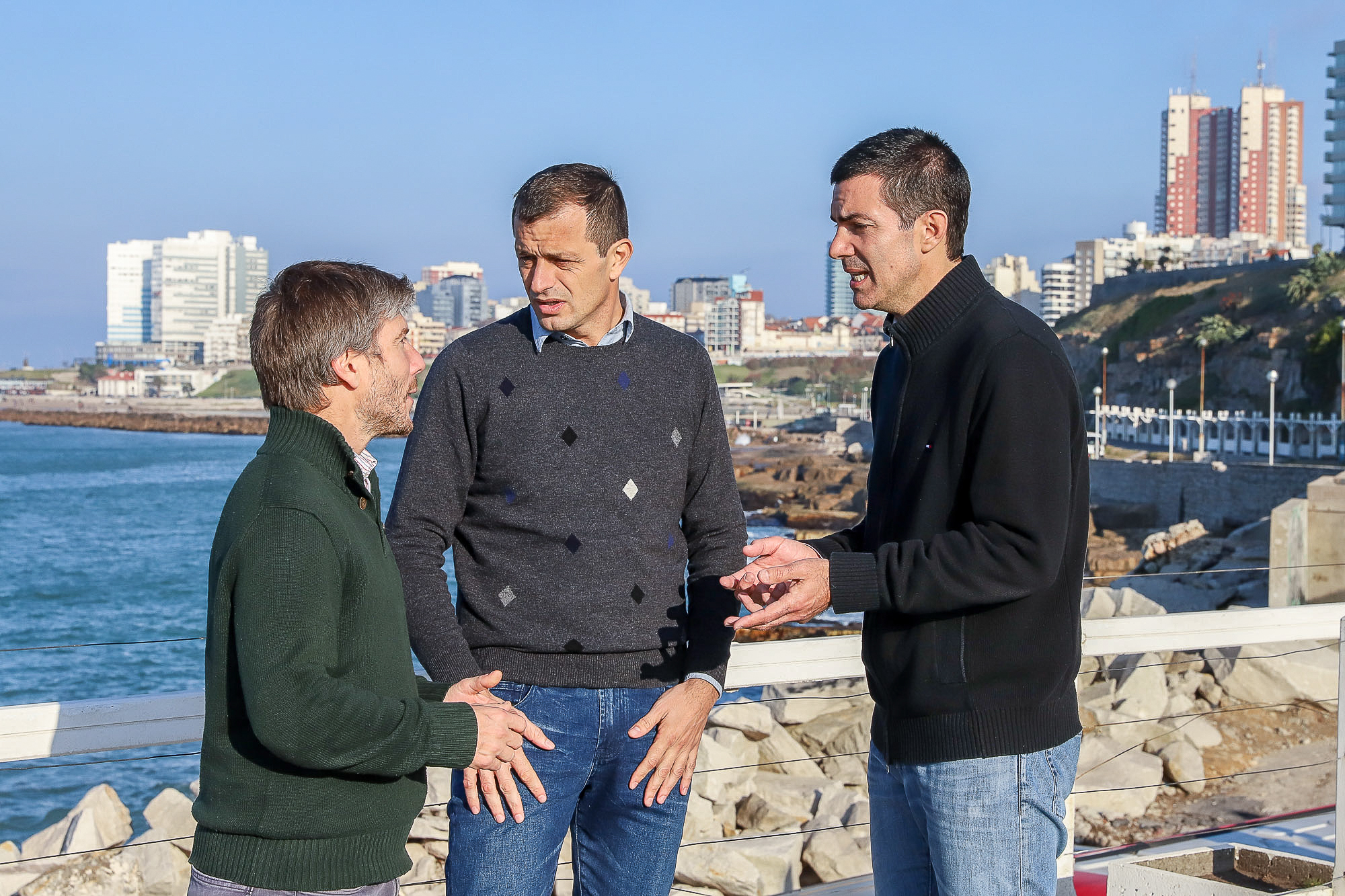 Juan Manuel Urtubey, Eduardo Bali Bucca y Santiago Bonifatti, conversan sobre temas referidos a la campaña con el fondo de la ciudad de Mar del Plata.
(Foto: Prensa Frente Renovador)