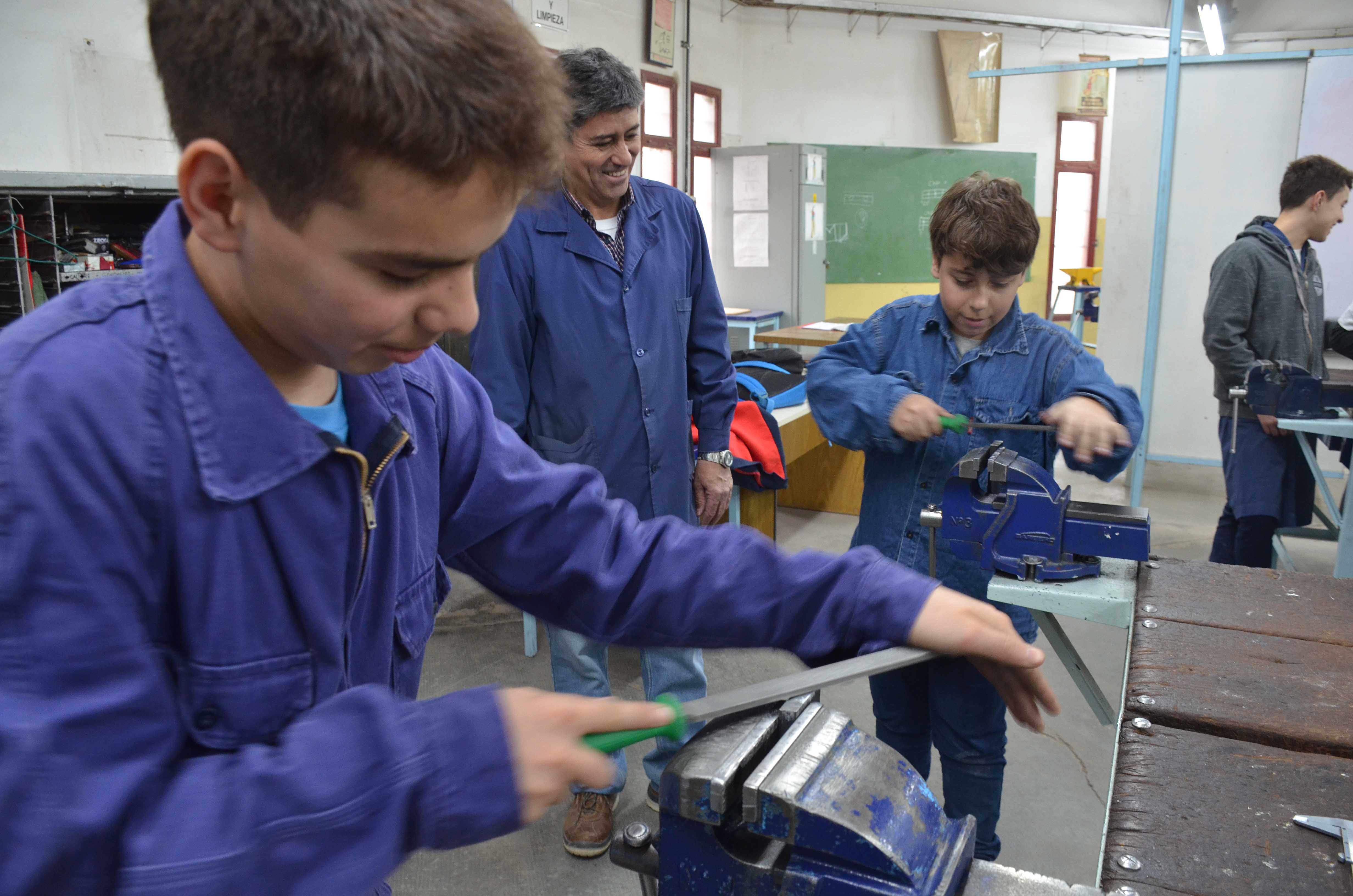 Los chicos preparan las piezas que usarán para construir una impresora braile. Foto: Yamil Regules.