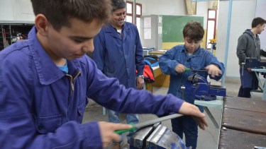 Los chicos preparan las piezas que usarán para construir una impresora braile. Foto: Yamil Regules.