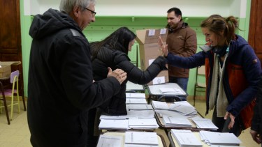 Dos mujeres fiscales de mesa se saludan antes del recuento de votos. Foto: Alfredo Leiva