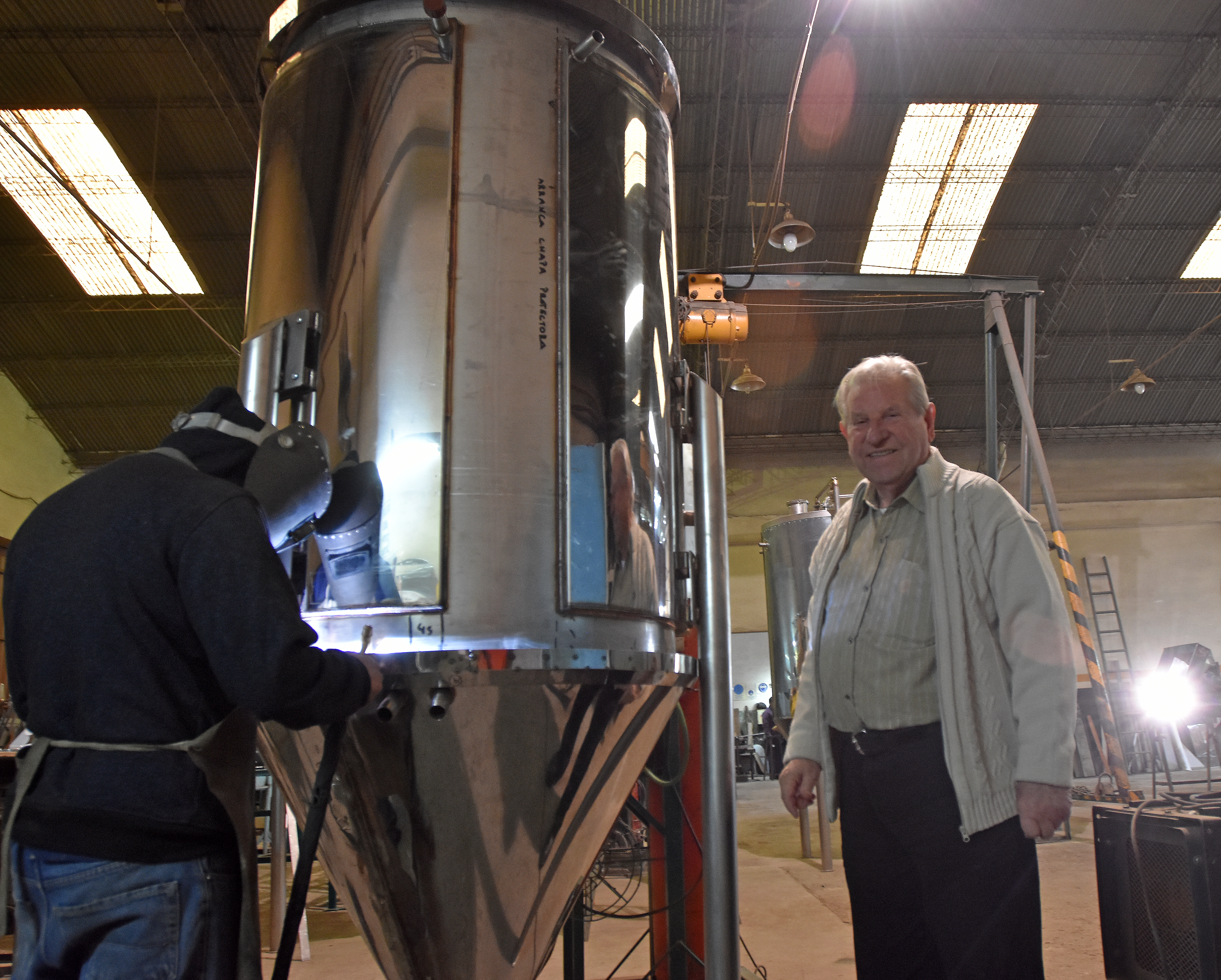 Beinaravicius en su fábrica junto a uno de los tanques de acero inoxidable para hacer cerveza que encargó una empresa regional.