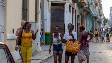 Una típica escena de La Habana, Tres empleadas salen de sus trabajos, a pura sonrisa.