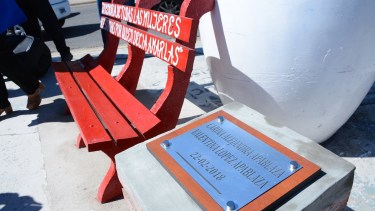 El banco rojo y la placa que recuerda a Carina y Valentina en Cutral  Co