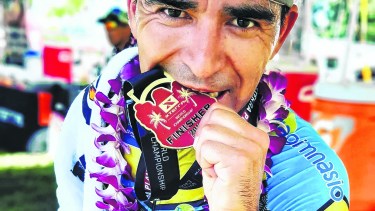 Morales y uno de los premios que obtuvo en el XTerra de Hawaii.