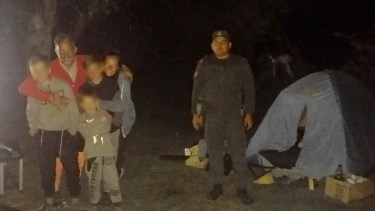 Un gendarmer junto a la carpa y la familia que era buscada en el lago Hess. Gentileza