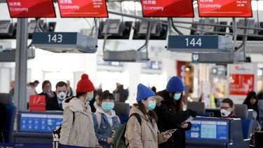 En el check in de un vuelo en Beijing, las máscaras también son protagonistas. (Foto AP)