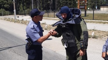 Un agente de la PSA se dispone a acercarse al artefacto encontrado en el acceso a un supermercado en Bariloche. Foto: Gentileza Policía