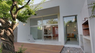 El living, comedor, cocina y bibliotecta -un gran ambiente único- dan al contrafrente, abierto al patio trasero con un hermoso y añejo árbol.