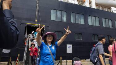 Una turista desciende del 'MS Westerdam' en Sihanoukville (Camboya) luego de que le negaran permiso en varios puertos.