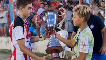 El capitán de campeón 12 de Marzo (La Plata) le entrega la copa del 2° puesto a su colega de Buena Parada de Río Colorado. Los valores de la amistad deportiva, por encima de la competencia.