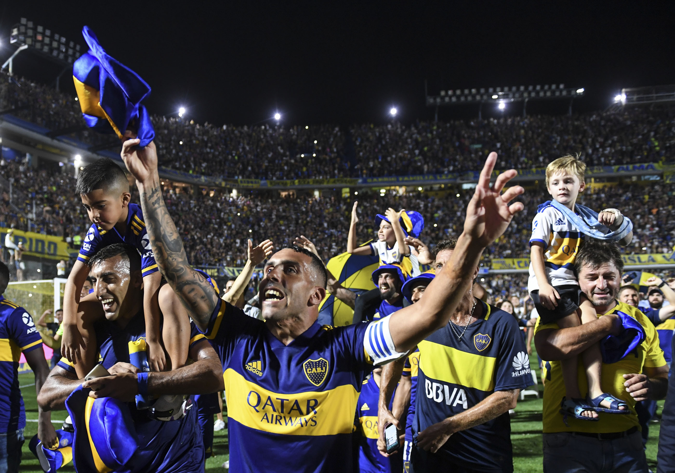 Los jugadores de Boca,  encabezados por Carlos Tevez, en la vuelta olímpica del plantel, festejan con la hinchada el nuevo galardón. (Foto/Télam)