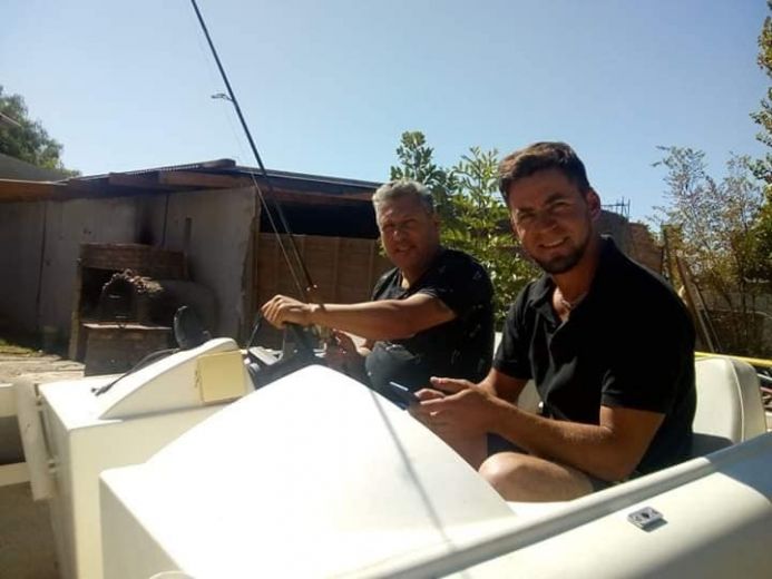 Yendo de la lancha al living. El guía de pesca Pablo Oscar Blasco arregla una embarcación en su casa en Cipolletti y hace atado de moscas en vivo desde las redes. Acá, con su suegro, Edgardo León. 