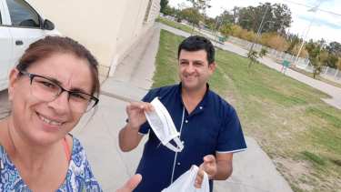 Mónica entregando los barbijos en el estacionamiento del Hospital. Foto: Facebook. 