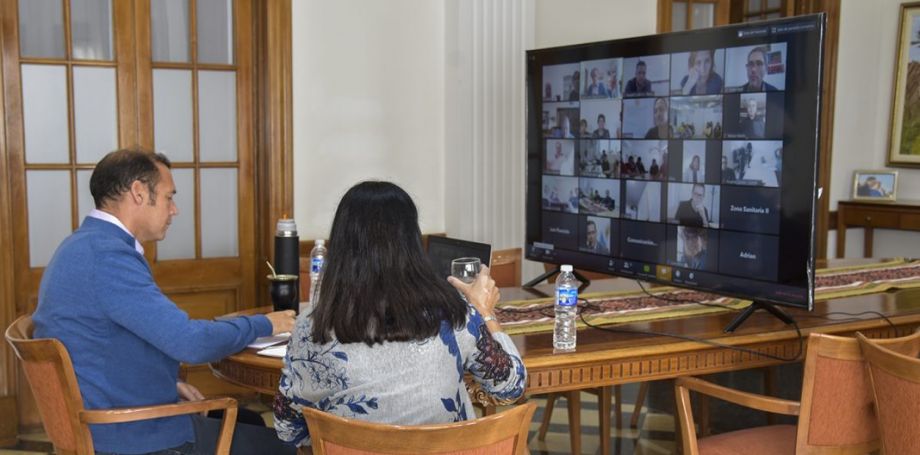 El gobernador Omar Gutiérrez y la ministra Andrea Peve (de espaldas) mantuvieron un encuentro virtual con integrantes del sistema de salud. Foto Neuquén Informa