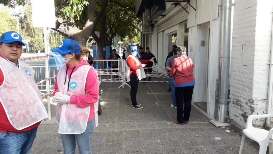 Personal municipal asiste a los vecinos que llegan al banco Nación. (foto y video Juan Thomes)