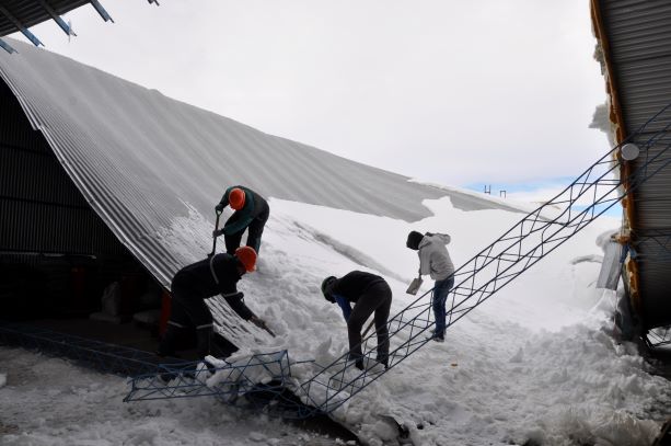 Trabajadores de la empresa despejan la nieve para tratar de rearmar el lugar y poder retomar la producción. (Foto. José Mellado)