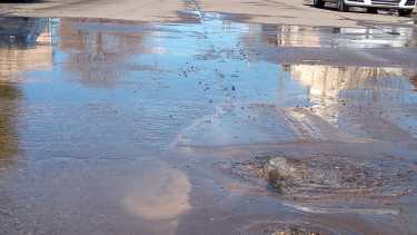 La presión del agua rompió el asfalto y ahora sale a borbotones. (foto: Luis Leiva)