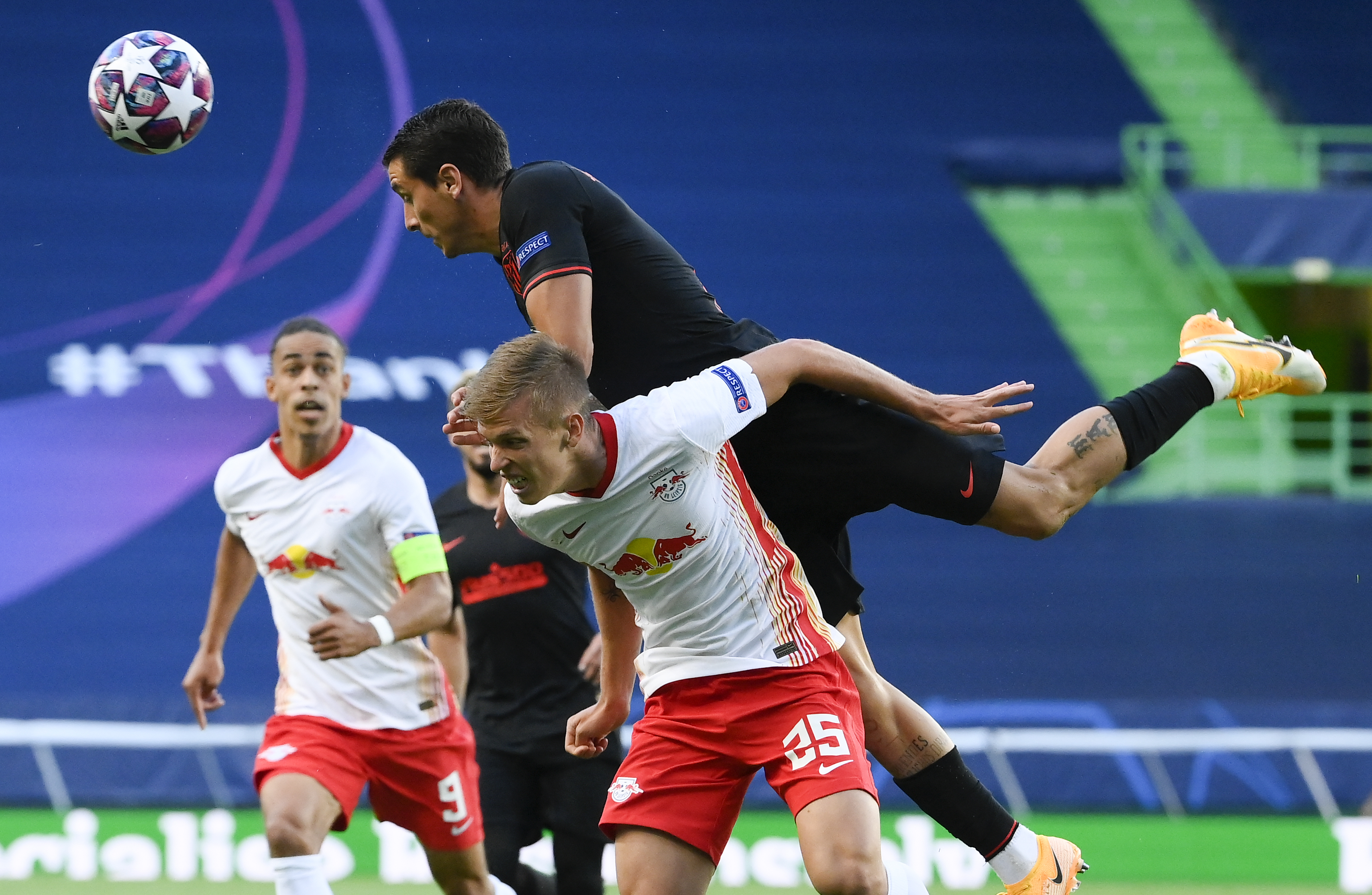 Jose Gimenez salta junto a Dani Olmo (Leipzig) en el partido que se juega en el estadio Jose Alvalade de Lisboa. (Lluis Gene/Pool Photo via AP)