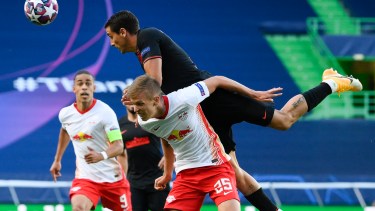 Jose Gimenez salta junto a Dani Olmo (Leipzig) en el partido que se juega en el estadio Jose Alvalade de Lisboa. (Lluis Gene/Pool Photo via AP)