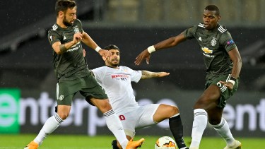Banega pelea por el balón entre Bruno Fernandes y Pogba. El Sevilla ira el viernes por su sexta Europa League. (AP Photo/Martin Meissner, Pool)