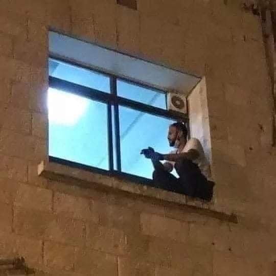 La imagen de Cisjordania que recorrió el mundo: un joven trepó las paredes de un hospital para ver a su madre.