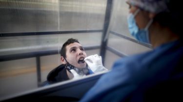 Un trabajador de la Salud hisopa a un joven con síntomas. Foto: Natacha Pisarenko para AP.-