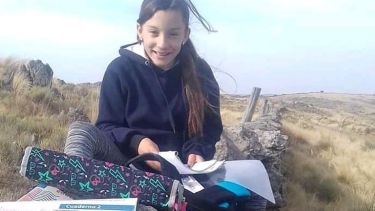 Romina con cada clase virtual, improvisaba un pupitre en la cima de una loma de Córdoba.  Foto: Gentileza Infobae