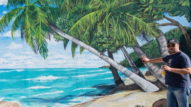 Enrique y el mural de la playa brasileña que le encargó a Chelo Candia en su casa en Roca, Alto Valle de Río Negro, al norte de la Patagonia. Fotos de Juan Thomes