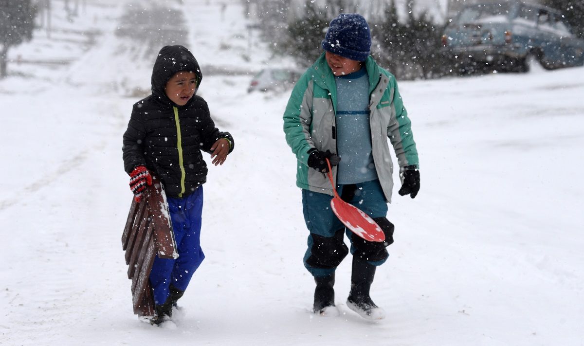 Los chicos aprovechan la nieve de octubre para tirarse con trineos en calles con pendientes de los barrios de Bariloche. Foto: Alfredo Leiva