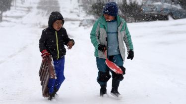 Los chicos aprovechan la nieve de octubre para tirarse con trineos en calles con pendientes de los barrios de Bariloche. Foto: Alfredo Leiva