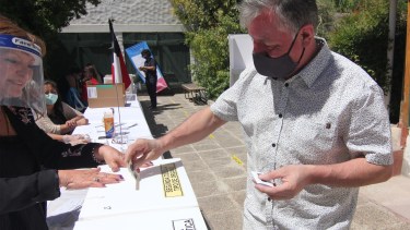 Cada votante se higienizaba sus manos con alcohol en gel al ingresar a votar  en Neuquén, para el plebiscito de Chile.  Foto: Oscar Livera 