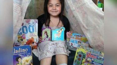 Una de las alumnas de la escuela 255 bajo su carpa de lectura y rodeada de libros. Gentileza