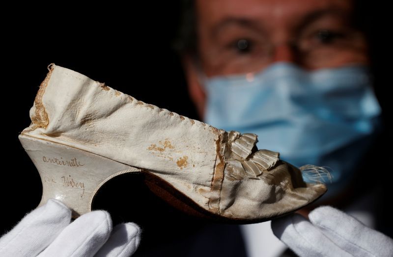 El subastador Jean-Pierre Osenat muestra el zapato que perteneció a la reina María Antonieta. Foto: Christian Hartmann para Reuters.-