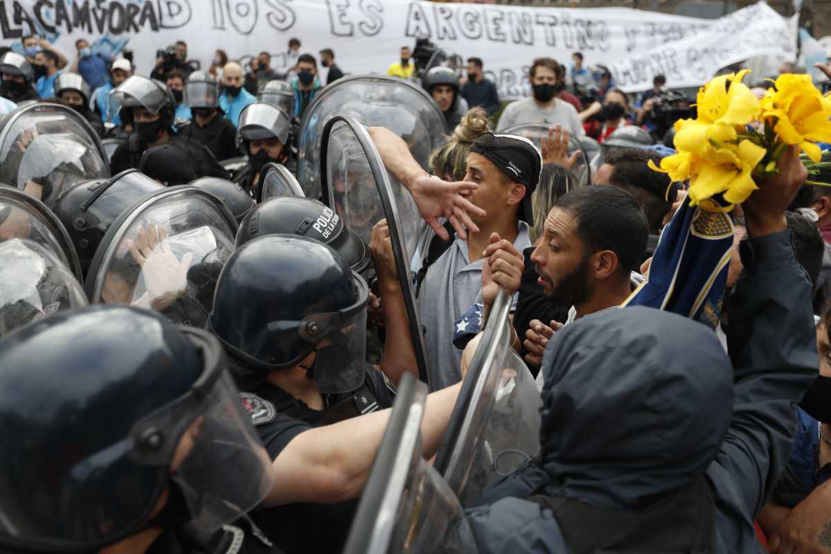 Fanáticos que esperaban en la fila para despedir a Diego Maradona se enfrentan con la policía. Foto: Natacha Pisarenko (AP)
