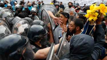 Fanáticos que esperaban en la fila para despedir a Diego Maradona se enfrentan con la policía. Foto: Natacha Pisarenko (AP)
