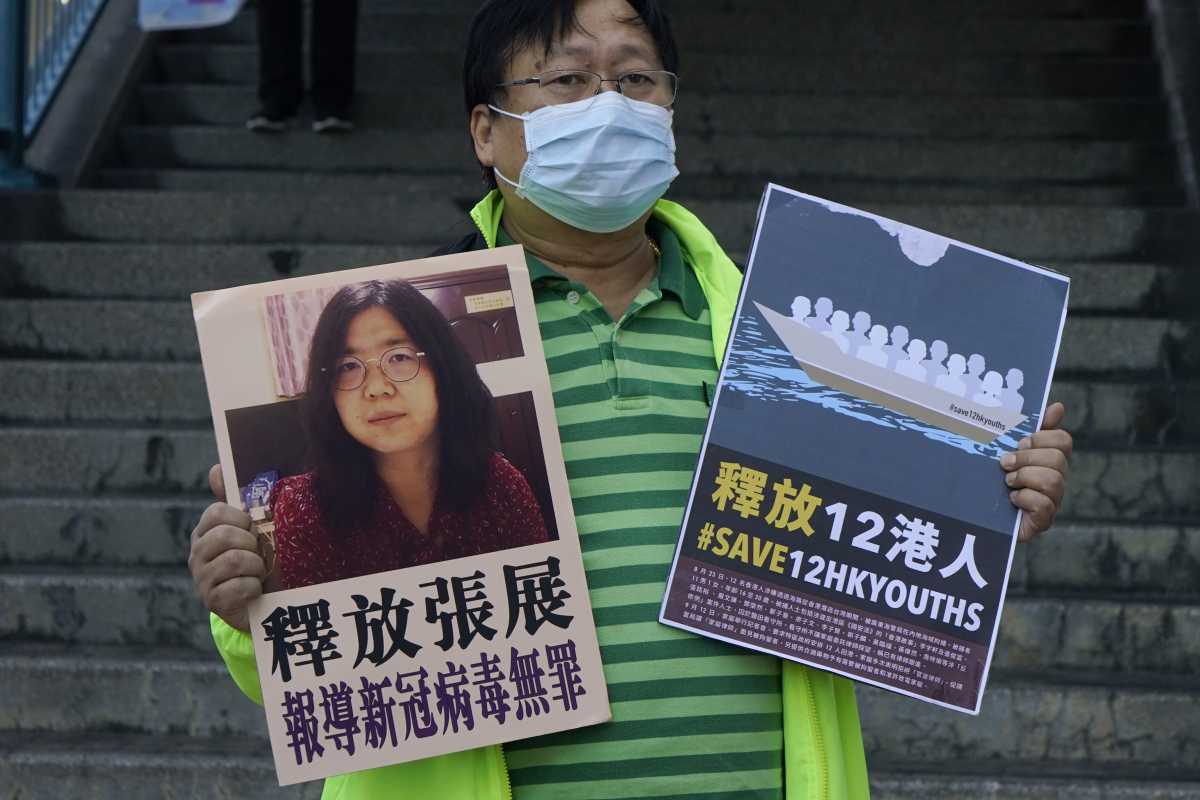 Un activista pide por la liberación de Zhang Zhan. Foto: AP 