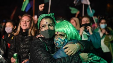 El pañuelo se transformó en barbijo por la pandemia. El viento de Neuquén no amedrentó a quienes esperaban el resultado de la votación. Foto Florencia Salto.