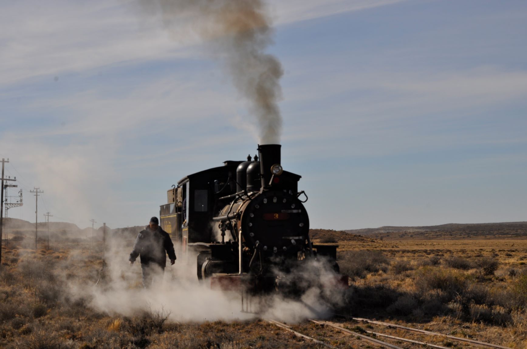 La imponente locomotora marchando y Juan emergiendo del vapor que la hace funcionar. El sábado 23 de enero volvió a surcar la meseta patagónica.  Foto: José Mellado. 
