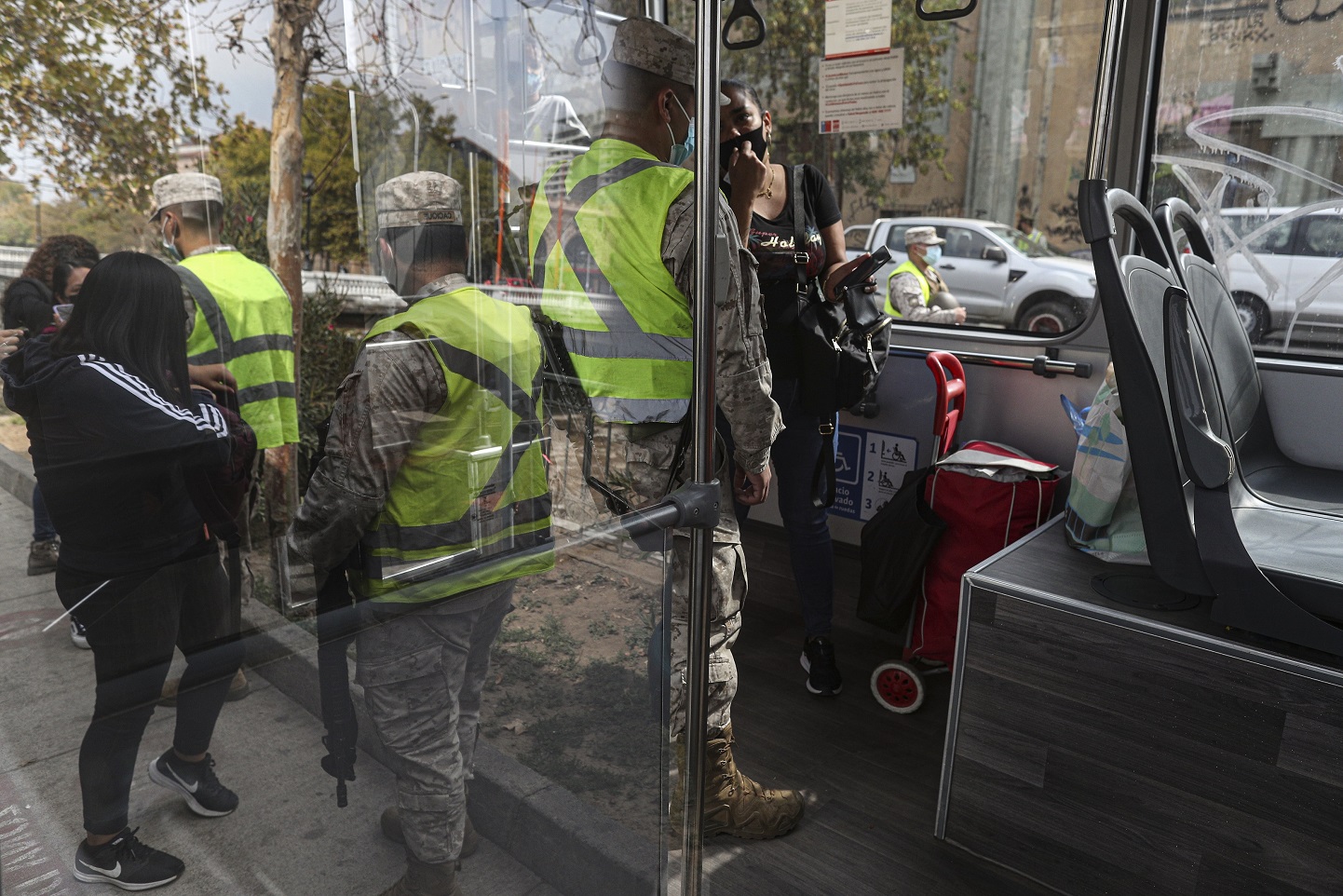 Soldados chequean los permisos de circulación de transeúntes en Santiago (AP Photo/Esteban Felix)